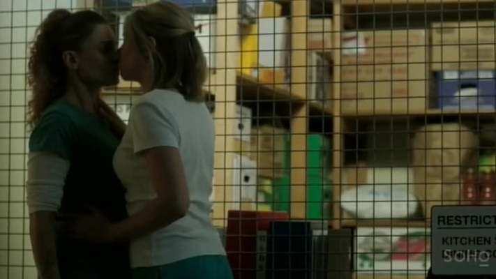 Bea and Allie share a sneaky kiss in the prison's kitchen.