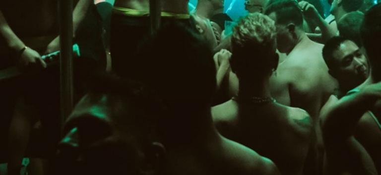 HOMO: a dance party dimly lit in dark green, shirtless bodies dancing